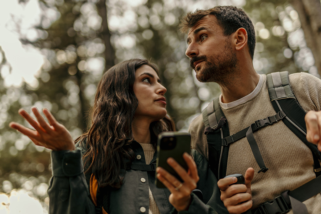 Pareja perdida en el bosque con móvil